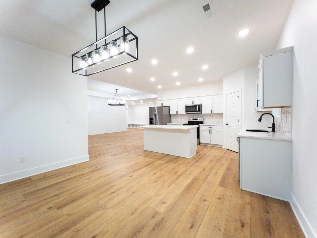 Kitchen and dining space connected by wood flooring
