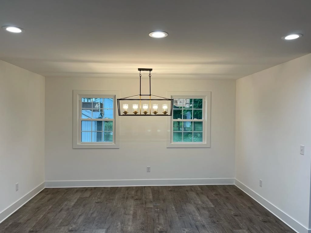 Dining area with a rectangular hanging light beneath two windows