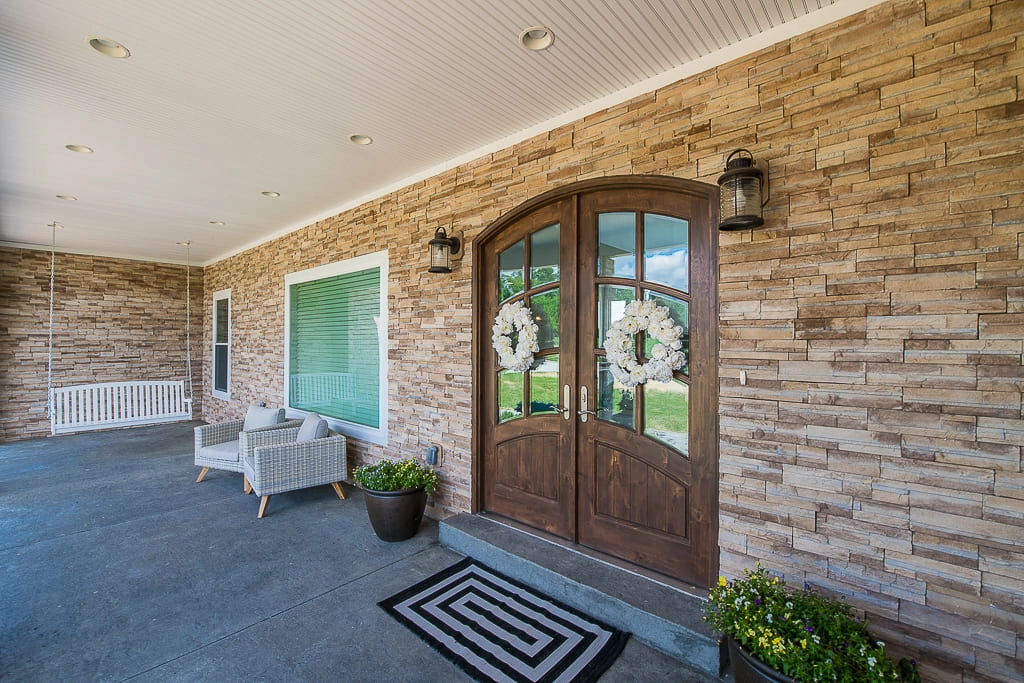 Stone cladding, glazed entry doors, window trim and finished soffits on the covered porch at 2238 Hansberry Road
