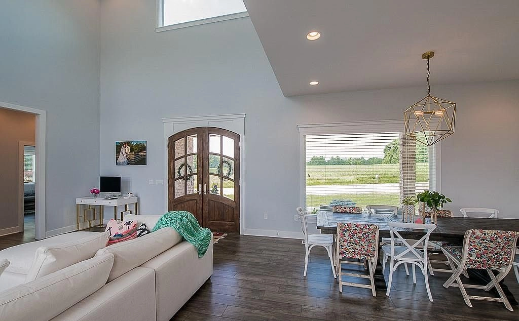 Tall entrance hall with arched wood double doors beside the dining area