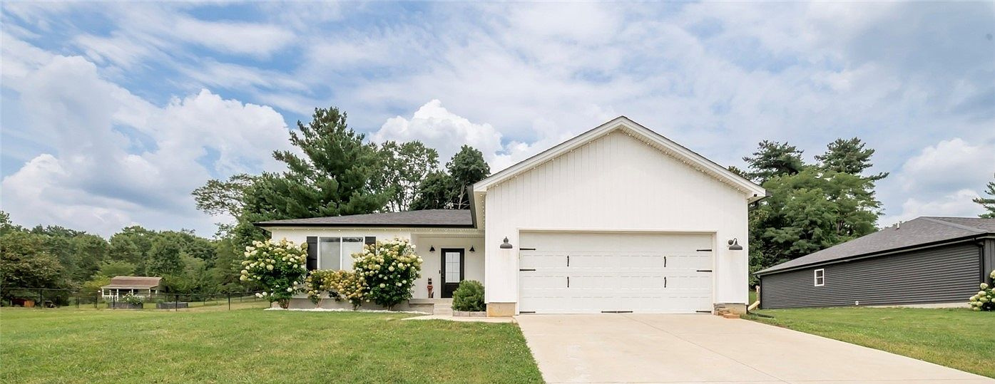 White home and landscaped front lawn at 1424 Utica Sellersburg Road