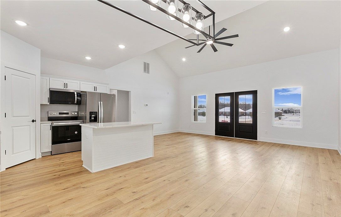 Open kitchen with a white island and wood floors at 5606 High Jackson Road