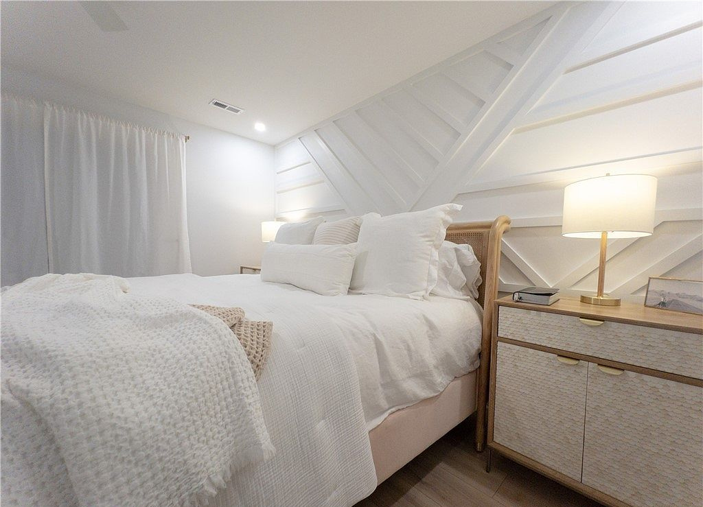 Bedroom with a textured feature wall and warm bedside lighting at 680 Sun Studio Drive