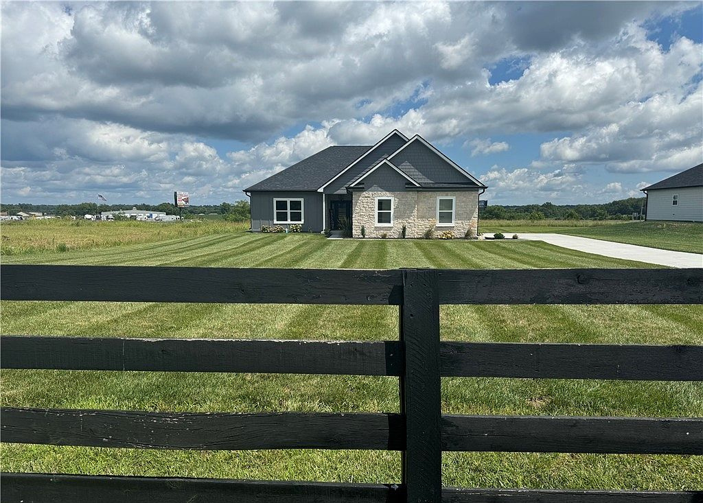 Home beyond a black rail fence under a dramatic sky at 685 Sun Studio Drive