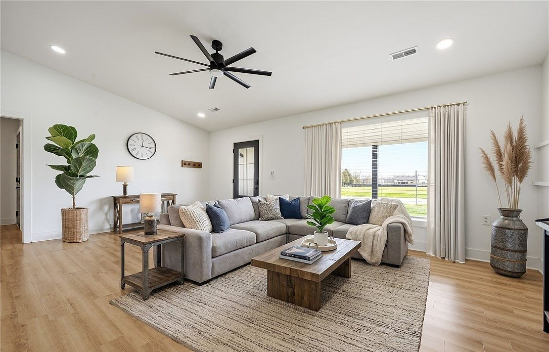Living room with a dark ceiling beam and wood floors at 8301 Salem Church Road